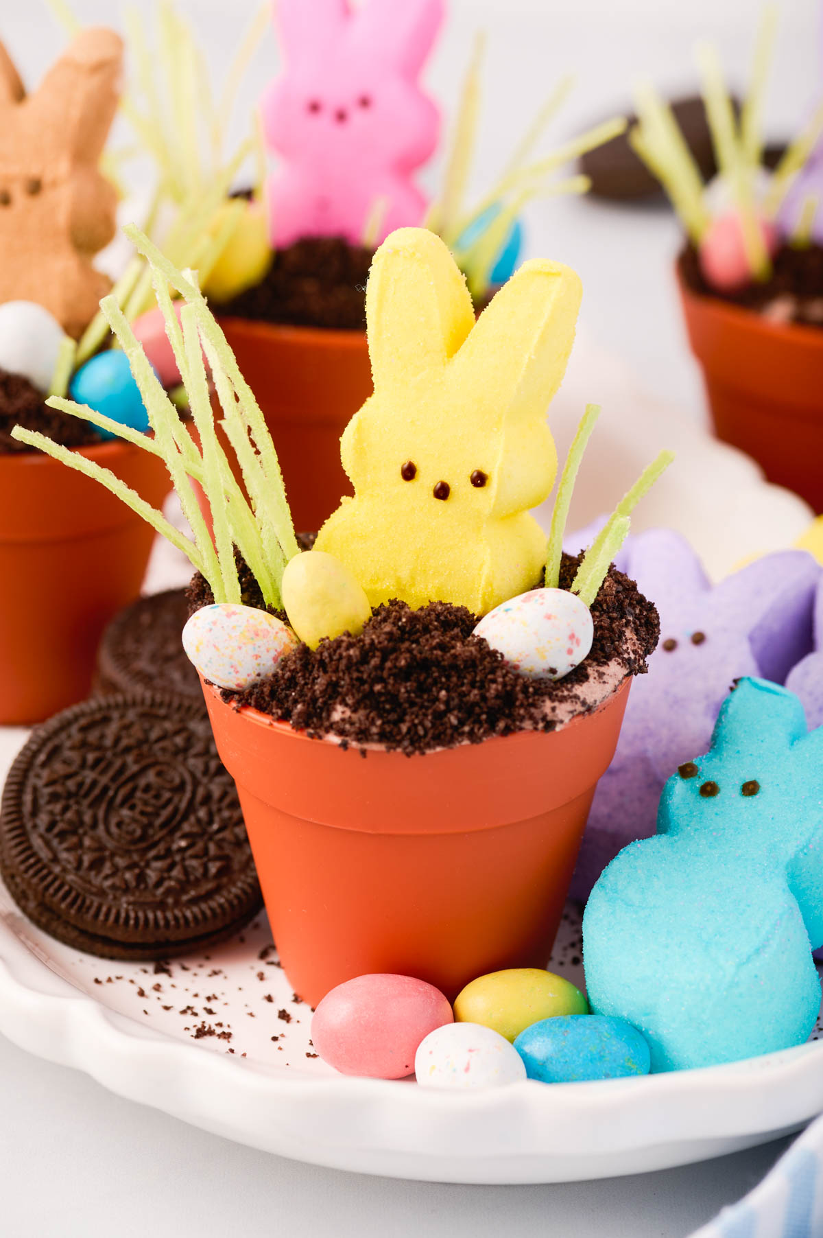 Easter dirt cups served in silicone garden pots with whopper eggs, bunny peep marshmallows and oreos