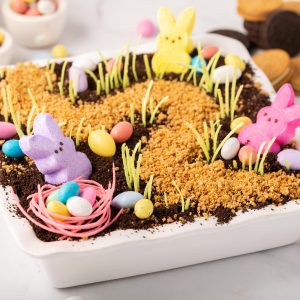 Easter Dirt Cake topped with edible grass, chocolate eggs and peeps marshmallow bunnies