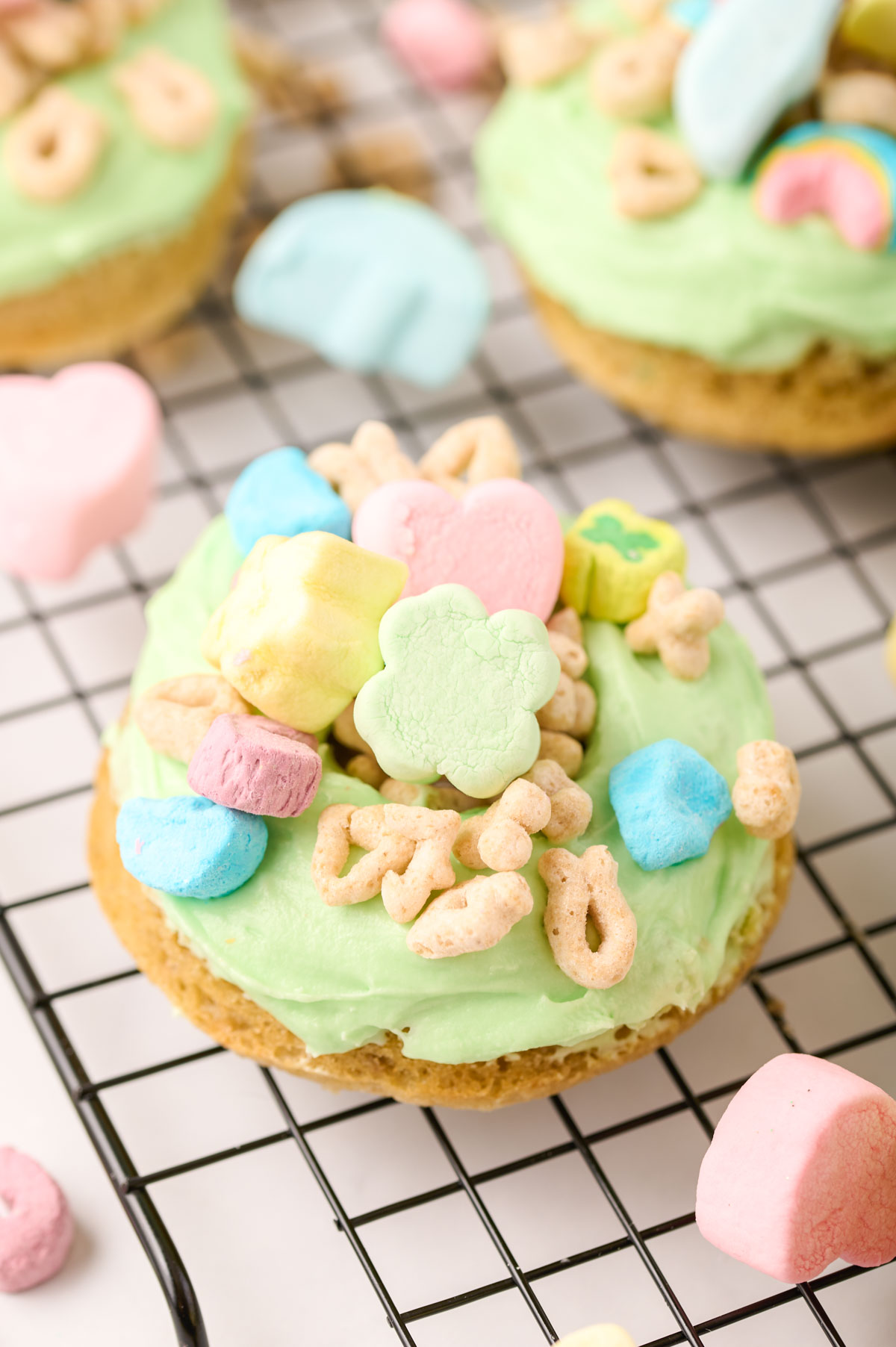 Close up of a lucky charms donut on a wire rack