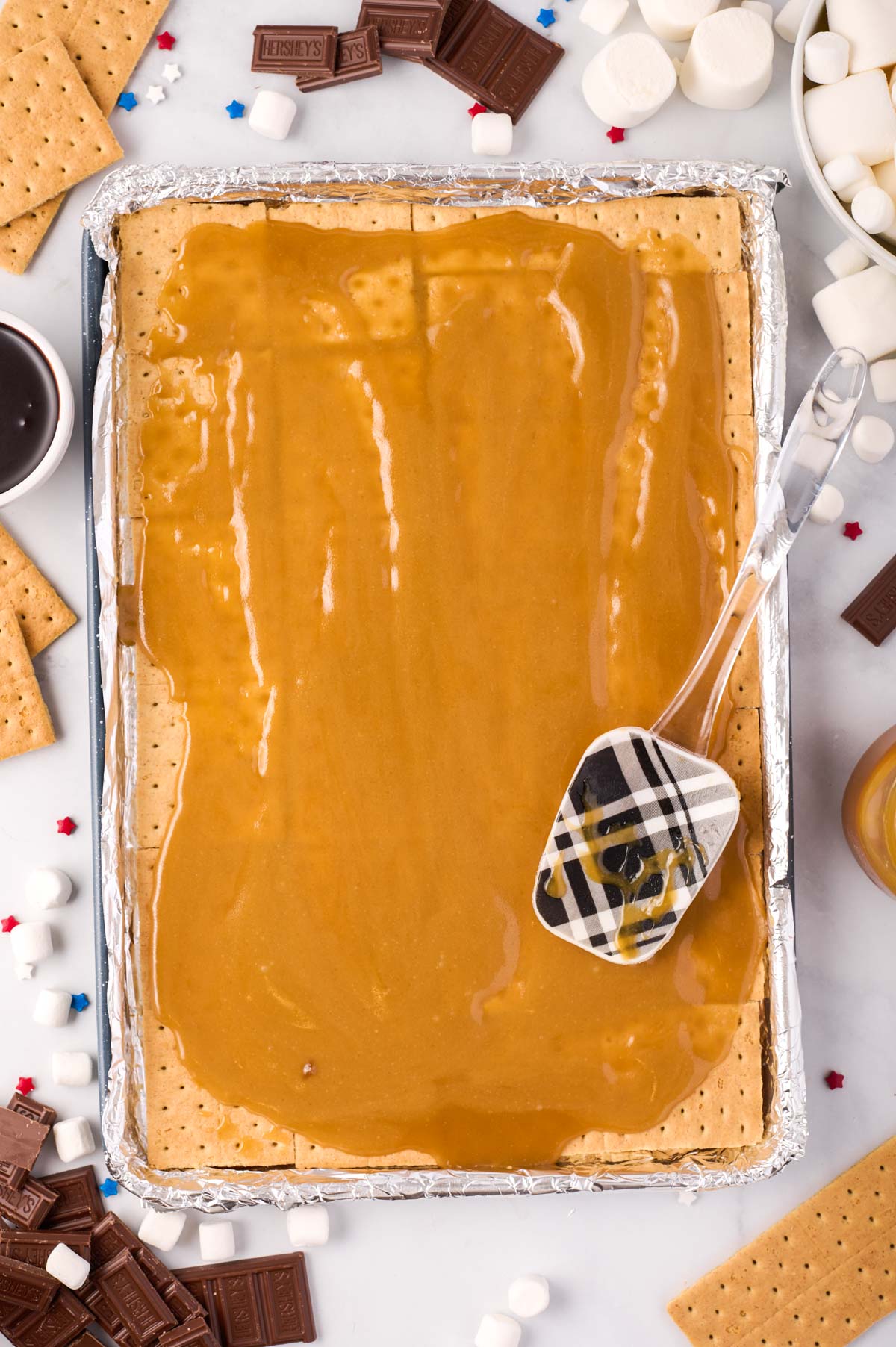 foil-lined baking sheet with a layer graham crackers topped with melted toffee