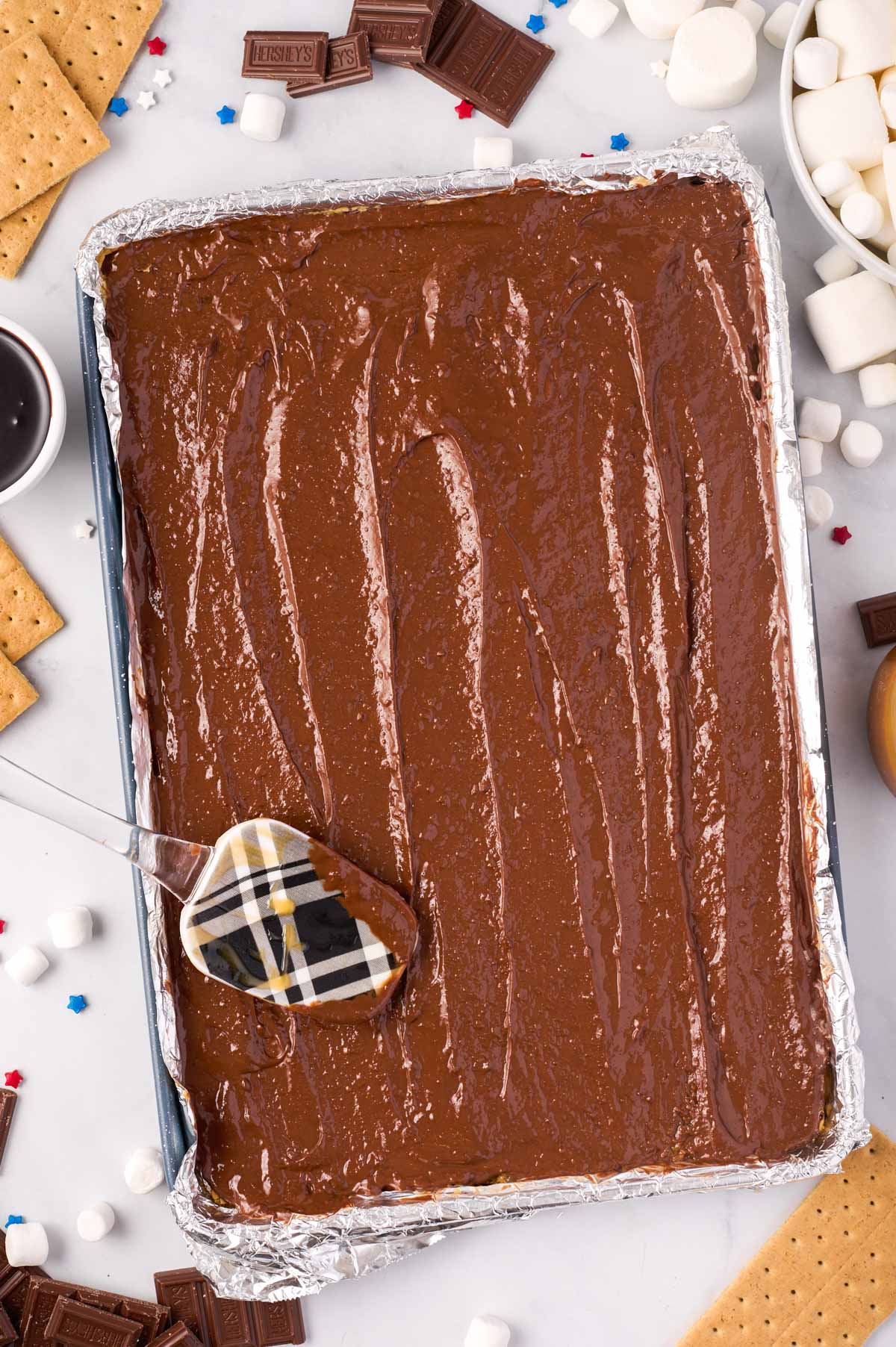 foil-lined baking sheet with a layer graham crackers topped with melted toffee and chocolate