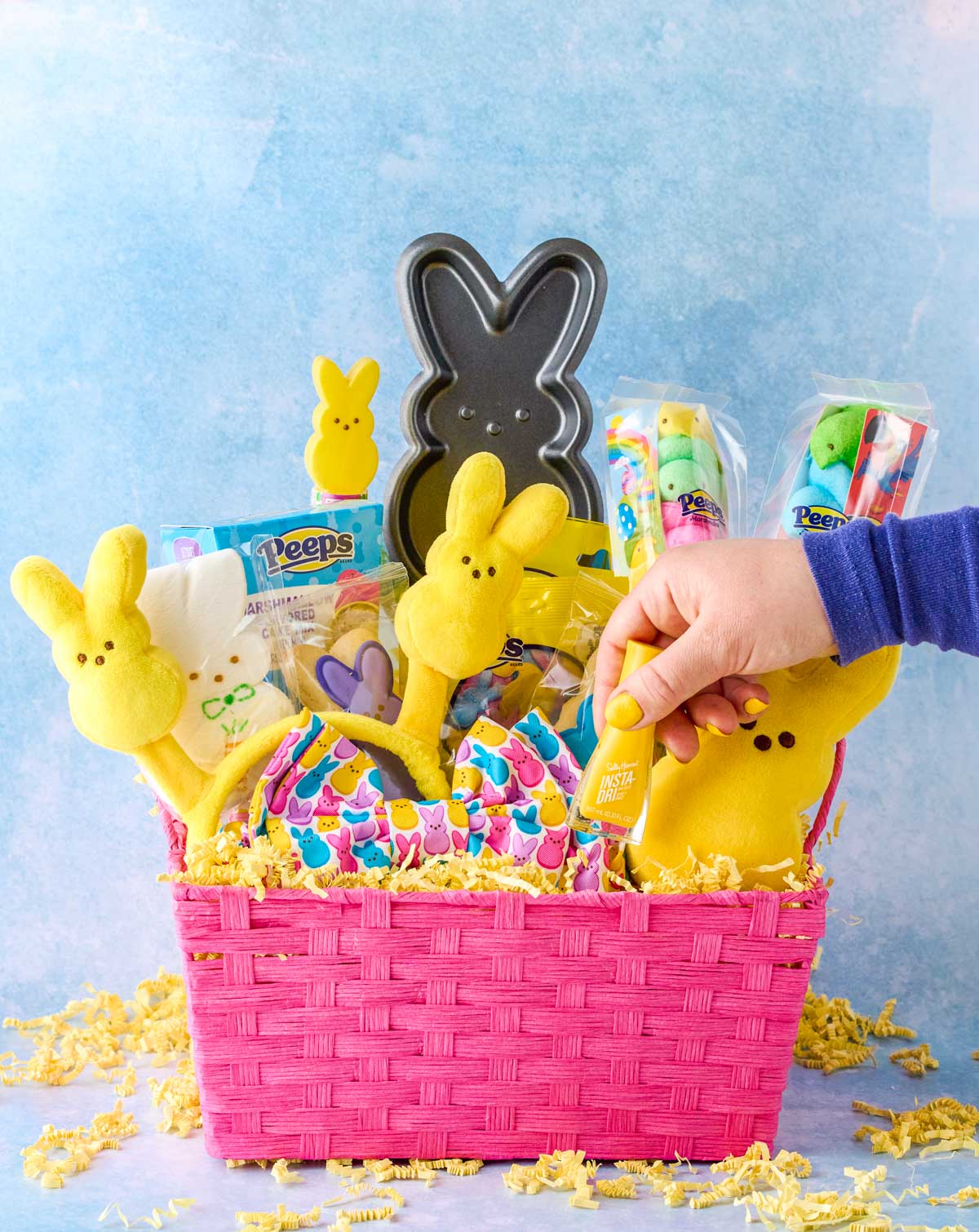 Hand reaching into Peeps Easter basket to place yellow nail polish