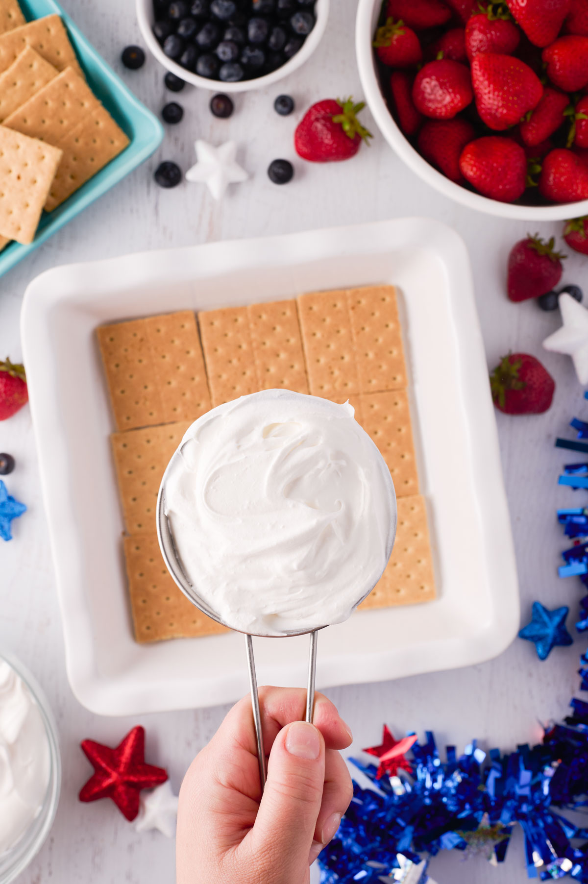 adding one cup of cool whip to a layer of graham crackers