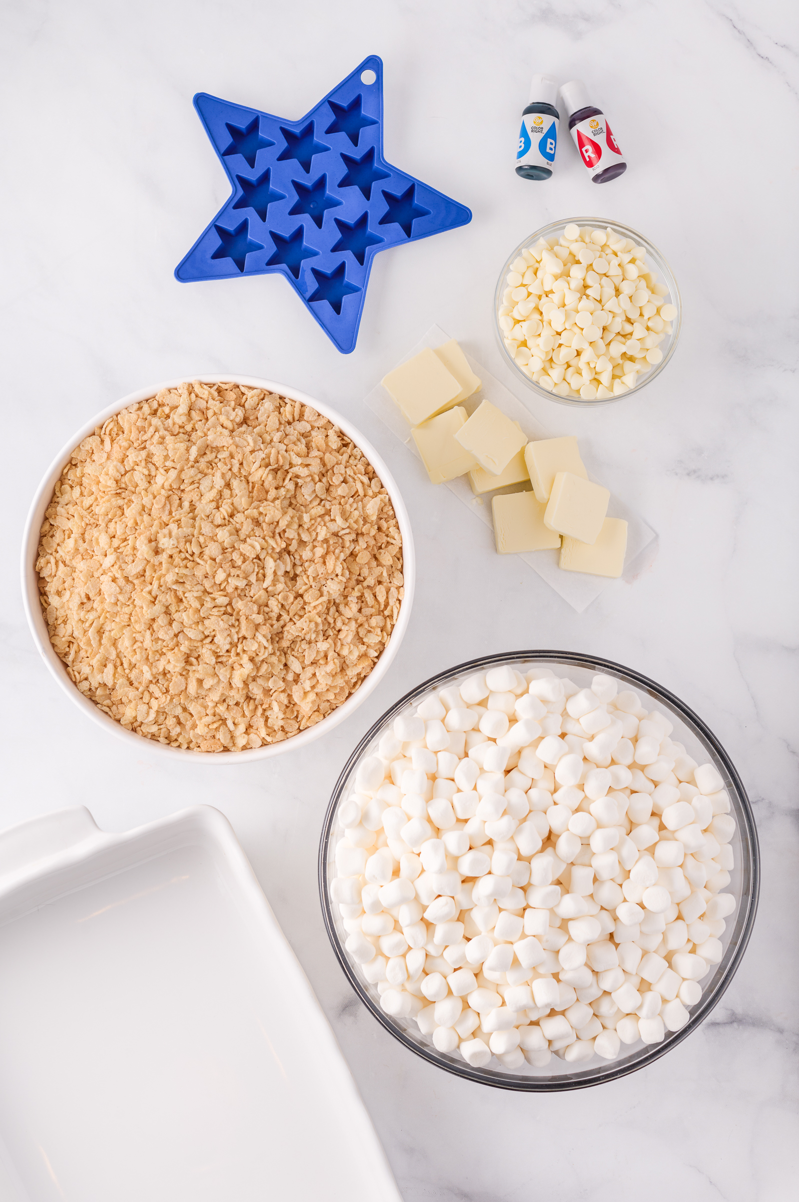 Ingredients to make 4th of July Rice Krispie Treats on a white marble surface