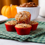 A pile of four mini pecan pie muffins on a green checkered linen